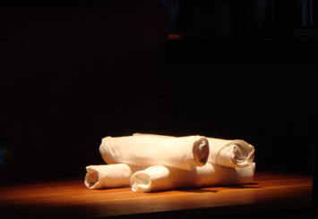 Photograph of dinner napkins rolled up and stacked on a dining table
